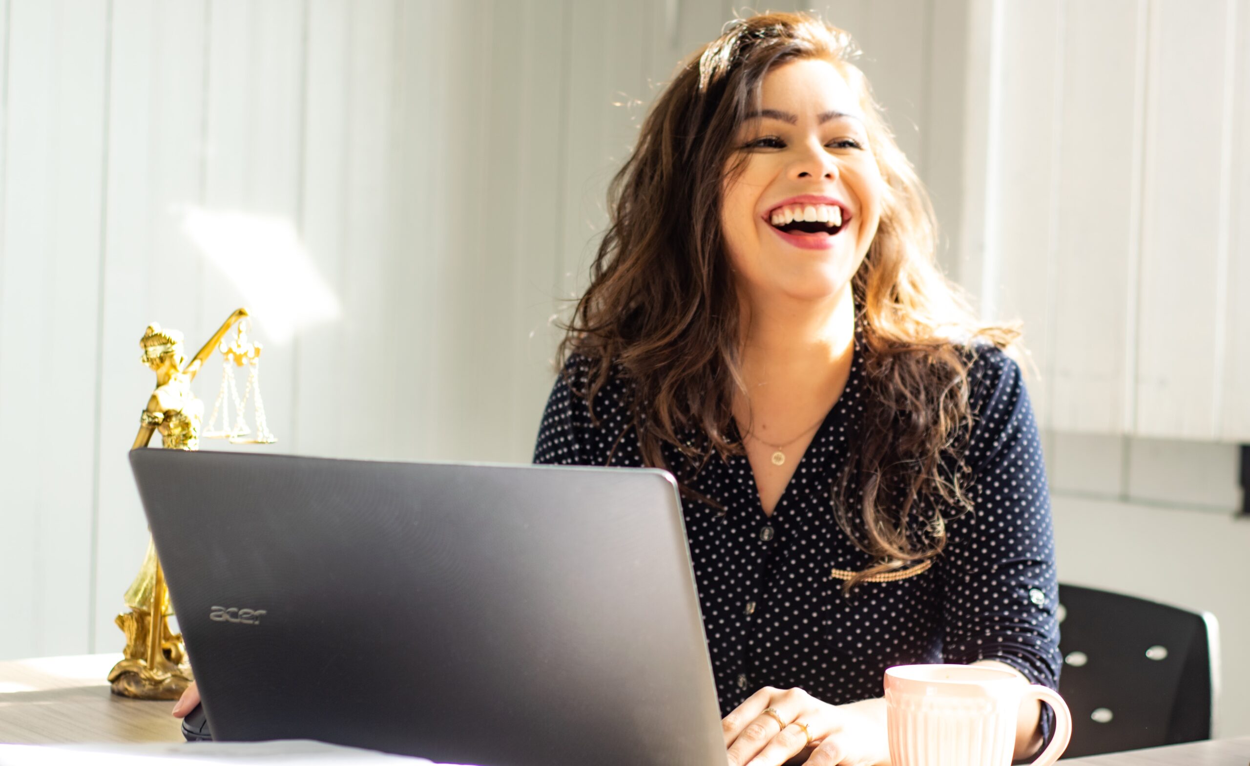 woman smiling while working on a laptop