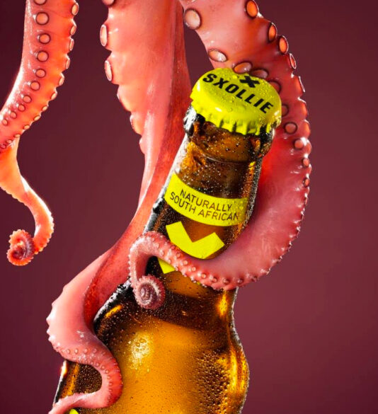 Three tentacles holding onto a bottle of Sxollie. Text reads "naturally south african"
