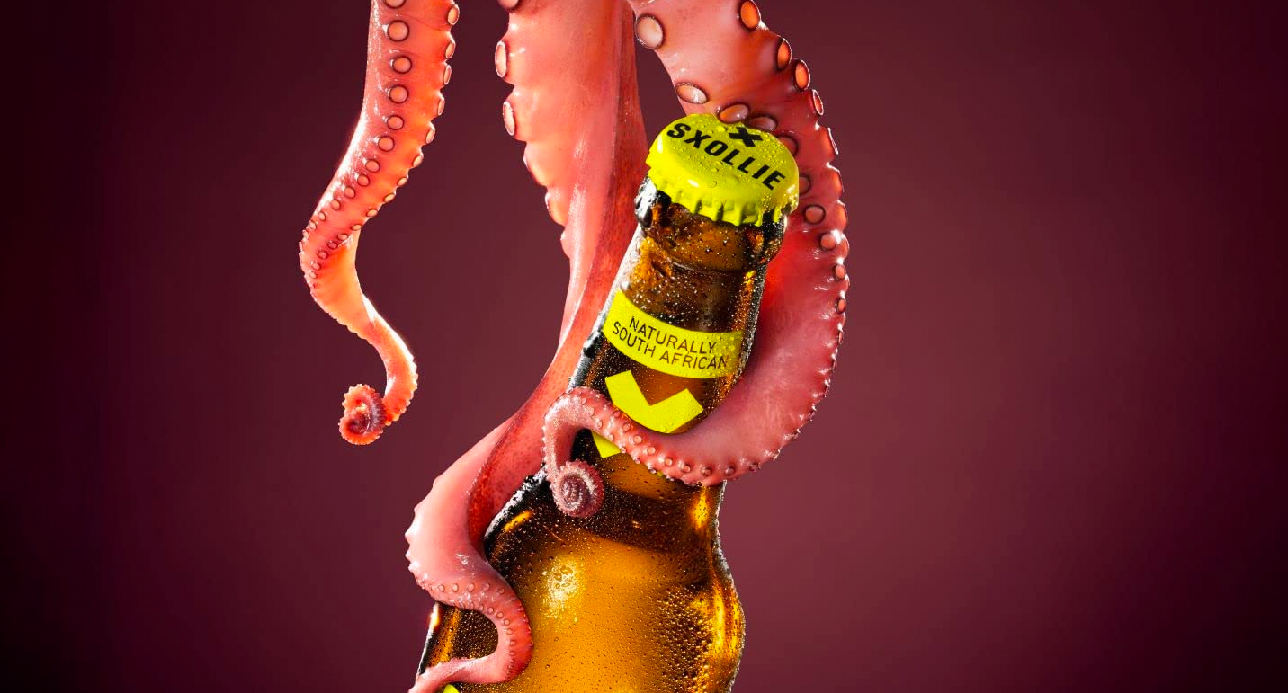 Three tentacles holding onto a bottle of Sxollie. Text reads "naturally south african"